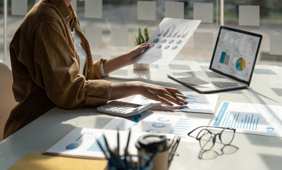 Woman analysing investment charts and portfolio reports at a desk