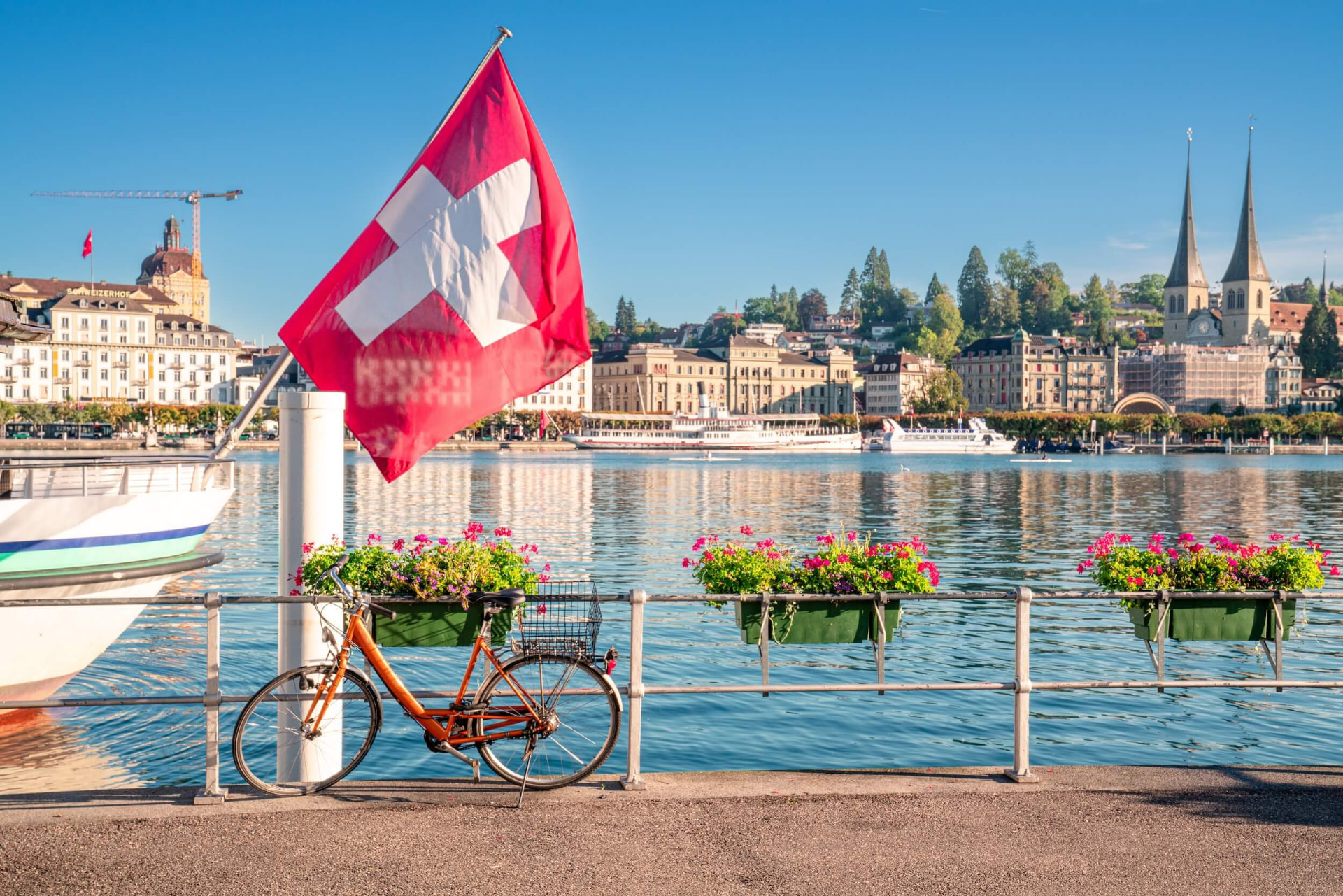 Swiss flag by Lake Lucerne with the old town and church spires in the background